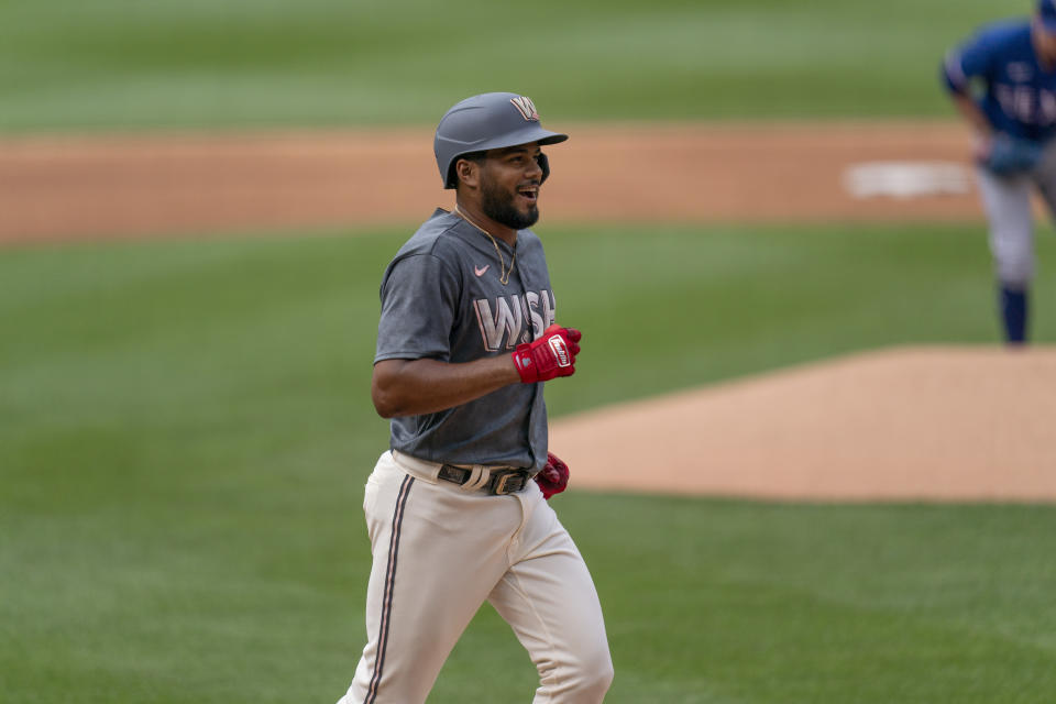 Washington Nationals' Jeimer Candelario, foreground, celebrates after hitting a home run during the first inning of a baseball game against the Texas Rangers, Saturday, July 8, 2023, in Washington. (AP Photo/Stephanie Scarbrough)