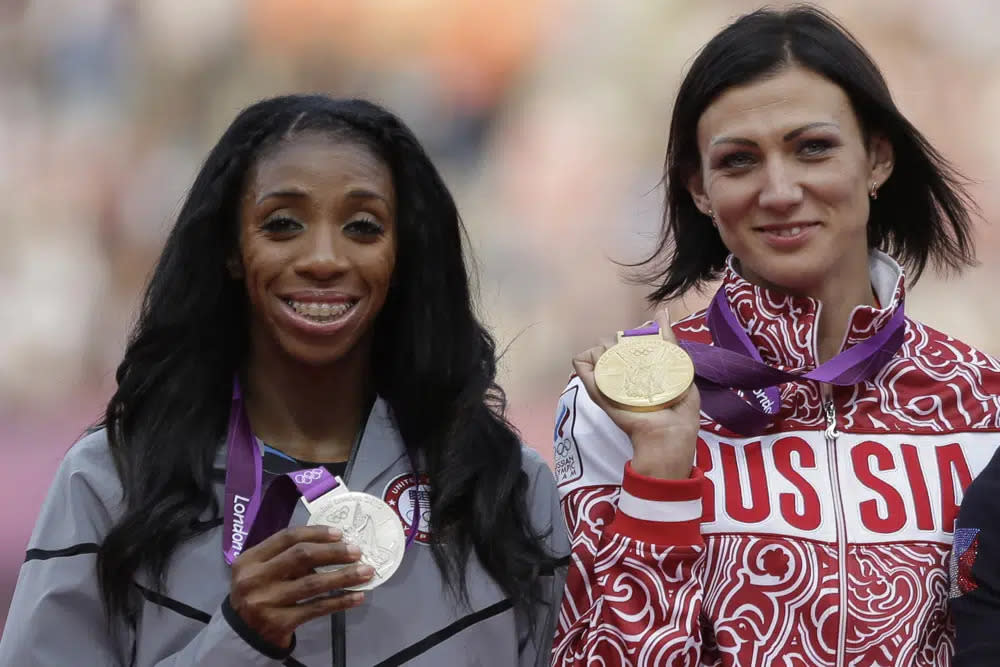Russia’s Natalya Antyukh holds the gold medal, United States’ Lashinda Demus, left, the silver medal a during a ceremony for the women’s 400-meter hurdles in the Olympic Stadium at the 2012 Summer Olympics, London, on Aug. 9, 2012. (AP Photo/Matt Slocum, FIle)