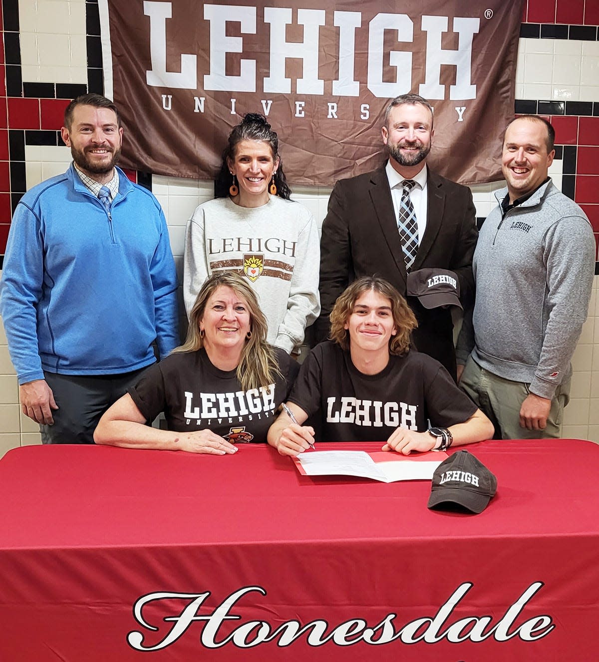 Honesdale multi-sport standout Aidan LaTourette has announced that he will be continuing his academic and athletic career at the NCAA level. The Hornet senior will attend Lehigh University in the Fall where he'll major in Engineering while running track and cross country. Aidan is pictured here with him Mom, Linda Pezzuti. Standing are (from left):  Head Track & Field Coach Paul Russick; Head Cross Country Coach Lindsey Pender; Assistant Cross Country Coach Kevin Kloss; Assistant Cross Country Coach Shawn Garing.