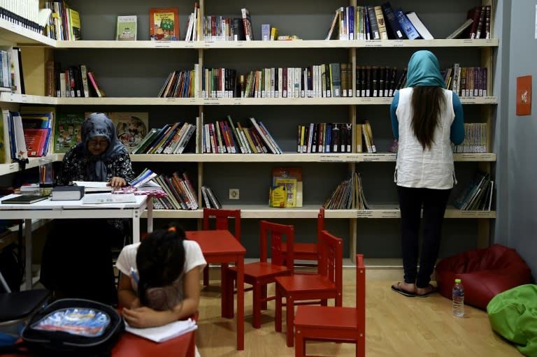 Refugees read books at a library set up by We Need Books, an international non-governmental organisation (NGO) hosting Syrian and Afghan women and children in central Athens