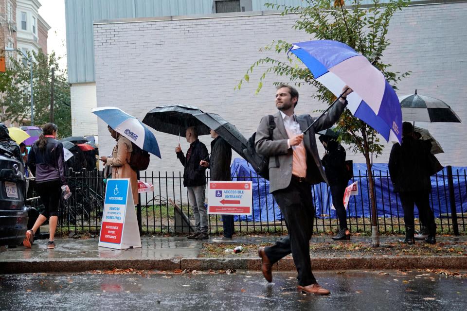 Voters line up in the rain outside Bright Family and Youth Center in the Columbia Heights neighborhood in Washington, Tuesday, Nov. 6, 2018.