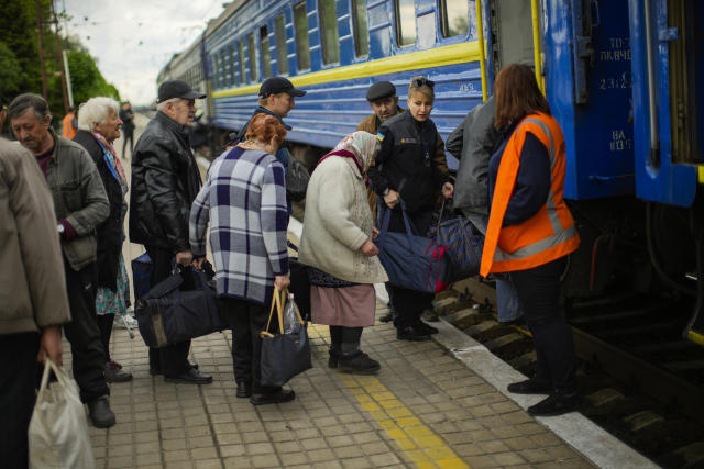 People fleeing from heavy shelling board an evacuation train at Pokrovsk train station, in Pokrovsk, eastern Ukraine, Sunday, May 22, 2022. Civilians fleeing areas near the eastern front in the war in Ukraine Sunday described scenes of devastation as their towns and villages came under sustained attack from Russian forces. (AP Photo/Francisco Seco)