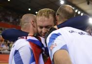 Great Britain's Chris Hoy celebrates with his coaches after crossing the finish line to win the gold medal in the London 2012 Olympic Games men's keirin final cycling event at the Velodrome in the Olympic Park in East London on August 7, 2012