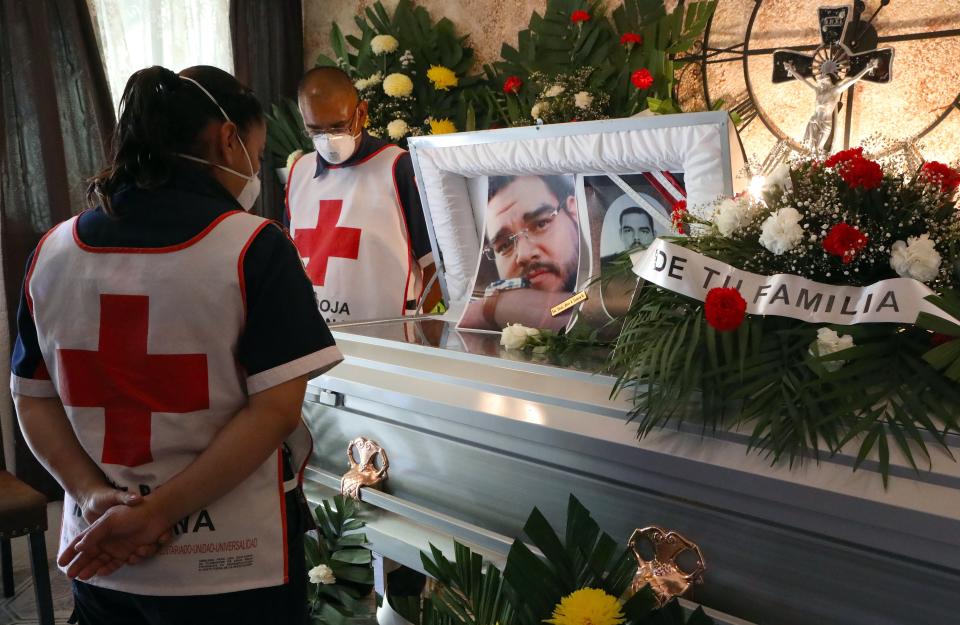 Paramédicos de la Cruz Roja Mexicana y familiares de Juan Andrés García, paramédico de la Cruz Roja y enfermero del IMSS que murió de COVID-19, lloran durante su funeral en Ciudad Juárez, Estado de Chihuahua, Foto de HERIKA MARTINEZ / AFP a través de Getty Images.