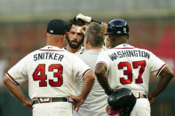 A member of the Atlanta Braves training staff tends to a small cut on Dansby Swason's forehead after he slid headfirst into second base with a double in the first inning of the team's baseball game against the New York Mets on Monday, Aug. 15, 2022, in Atlanta. Swanson stayed in the game. (AP Photo/John Bazemore)