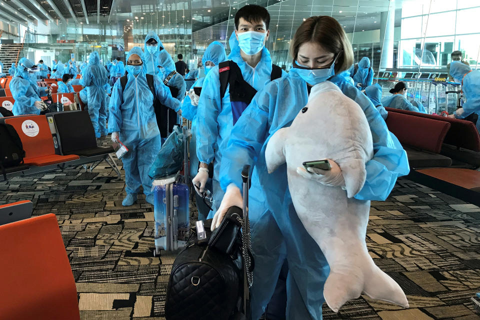 A Vietnamese woman carries a stuffed animal while boarding a repatriation flight from Singapore to Vietnam amid spread of the coronavirus disease (COVID-19) outbreak at Changi airport, Singapore August 7, 2020. Picture taken August 7, 2020. REUTERS/Mai Nguyen     TPX IMAGES OF THE DAY