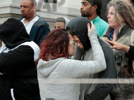 Andrea Irwin, mother of Tony Robinson, hugs her son Malik Robinson during a press conference at the State Capitol Thursday, Feb. 23, 2017 in Madison, Wis. The family of Tony Robinson, who sued the city of Madison after he was killed by officer Matt Kenny in 2015, has settled the suit for $3.35 million.