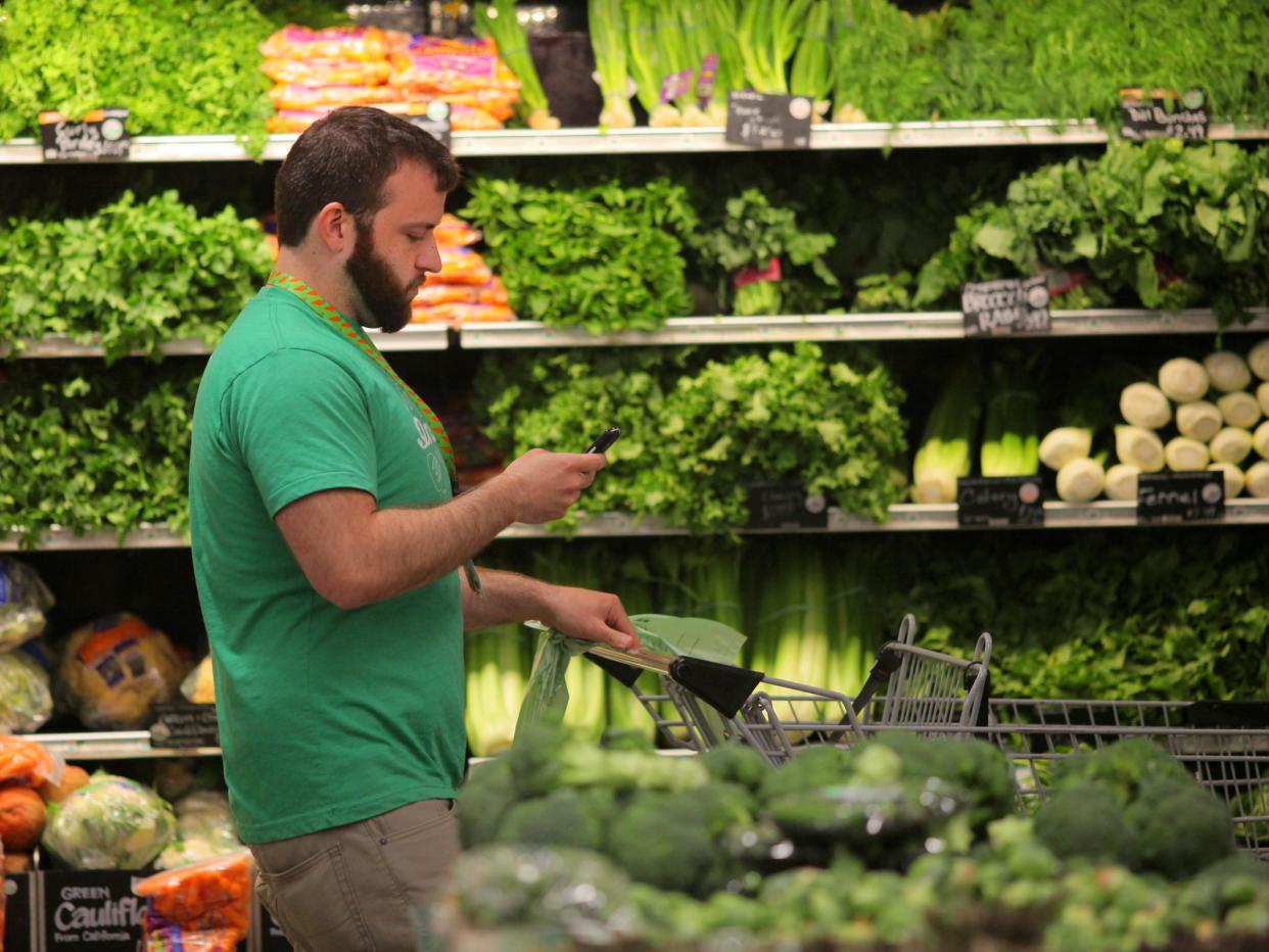 BOSTON, MA - MAY 28: Owen Amsler, an Instacart shift captain, shops for a customer in the Whole Foods Market in Boston's South End on May 28. 2015. A company called Instacart sends people into stores like Whole Foods to fulfill grocery delivery orders from other people. (Photo by Lane Turner/The Boston Globe via Getty Images)