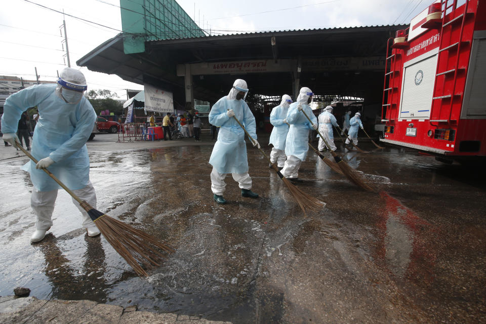 Workers clean the road outside shrimp market in Samut Sakhon, South of Bangkok, Thailand, Monday, Jan. 25, 2021. Thailand on Monday registered a new daily high of over 900 confirmed new cases of the coronavirus at the province near the capital Bangkok, where a major outbreak occurred in December. (AP Photo)