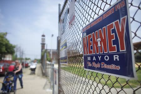 A woman pushes her child past a "Jim Kenney for Mayor of Philadelphia" sign on primary election day in Philadelphia, Pennsylvania on May 19, 2015. REUTERS/Mark Makela