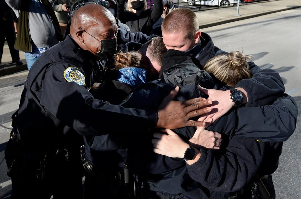 Nashville Metro Police Chief John Drake, left, and officers Amanda Topping, Michael Sipos, James Luellen, Brenna Hosey, and James Wells spend a moment in a group hug after the press conference on Sunday, December 27, 2020 in Nashville, Tenn. 