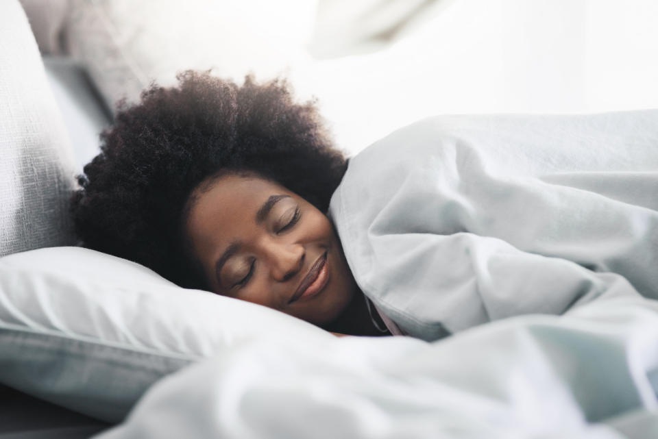 Happy woman sleeping in bed