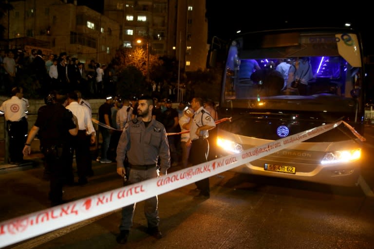 Israeli security forces gather at the scene where an Arab man on a Jerusalem bus stabbed an off-duty Israeli soldier before being shot dead, on October 12, 2015