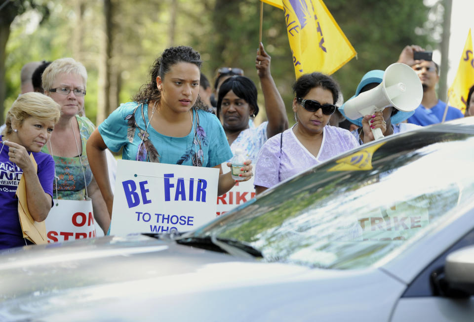 Nursing home workers glare into a car that crosses the picket line at Newington Health Care Center in Newington, Conn., Wednesday, July 11, 2012. Workers at five HealthBridge-owned nursing homes around the state went on strike last week after the health care company declined to return to the bargaining table. (AP Photo/Jessica Hill)