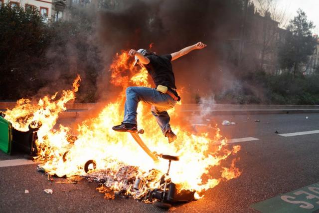 Un skater vuela sobre las llamas durante las protestas de este martes en Toulouse, sur de Francia