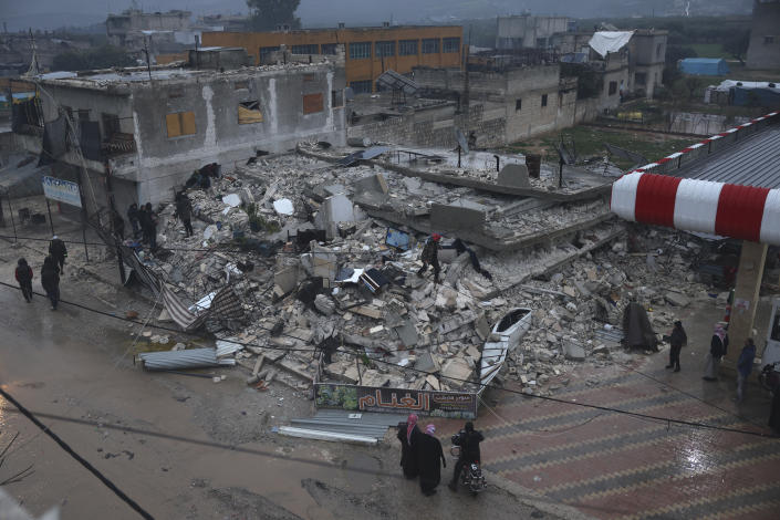 People search a collapsed building following an earthquake in Azmarin town, Idlib province, northern Syria, Monday, Feb. 6, 2023. A powerful earthquake has caused significant damage in southeast Turkey and Syria and many casualties are feared. Damage was reported across several Turkish provinces, and rescue teams were being sent from around the country. (AP Photo/Ghaith Alsayed)