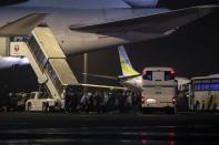 Passengers of the cruise ship Diamond Princess, where dozens of passengers were tested positive for coronavirus, board their plane at Haneda airport in Tokyo