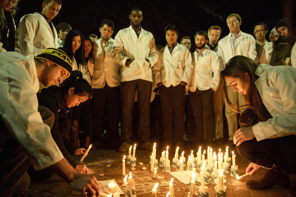 Dentistry students and others watch as a makeshift memorial is made during a vigil at the University of North Carolina following the murders of three Muslim students on February 11, 2015 in Chapel Hill, North Carolina. Craig Stephen Hicks, 46, has been charged with three counts of first-degree murder after the February 10, 2015  slayings in the North Carolina university town of Chapel Hill which sparked outrage amongst Muslims worldwide.  Police investigating the murders said they were studying whether the fatal shootings were religiously motivated, as calls mounted for the killings to be treated as a hate crime.(Brendan Smialowski/AFP/Getty Images)