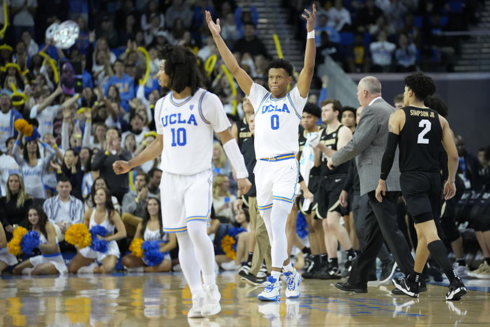 UCLA guard Tyger Campbell (10) and guard Jaylen Clark (0) celebrate during a timeout during the second half of an NCAA college basketball game against Colorado in Los Angeles, Saturday, Jan. 14, 2023. (AP Photo/Ashley Landis)