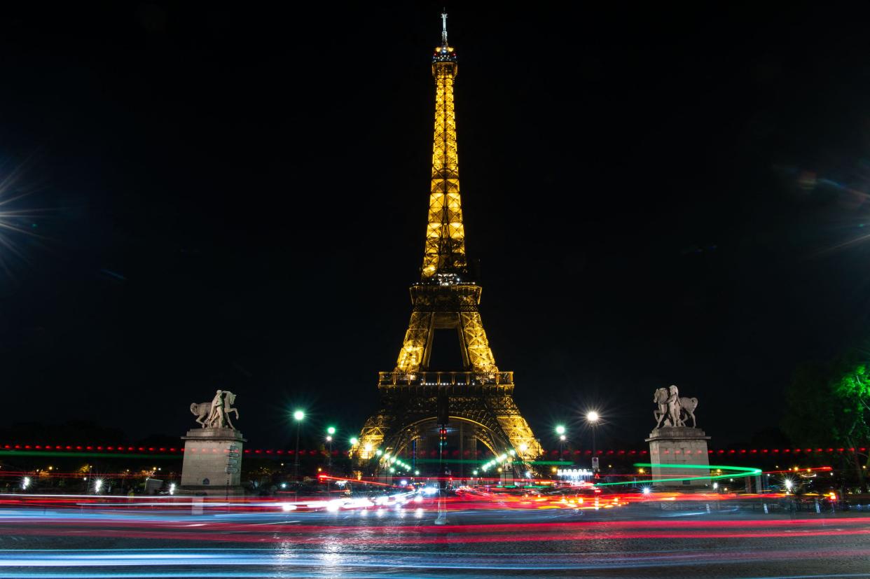 A picture taken at night on April 26, 2022 shows a view of the illuminated Eiffel Tower