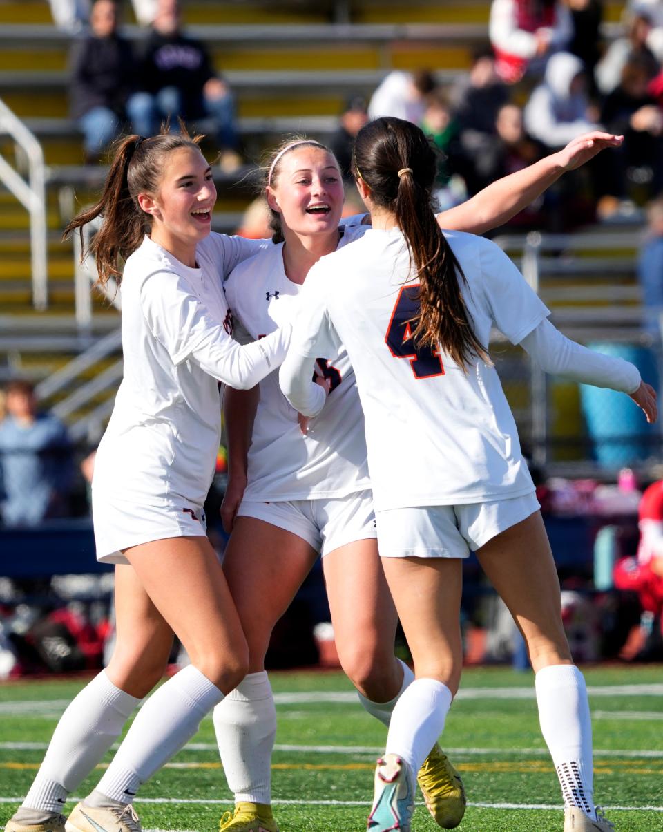 Kristine Squeglia, Abby Hawes and Maya Ritchie of Mountain Lakes, celebrate a first-half goal during the Group 1 final on November 23, 2023.