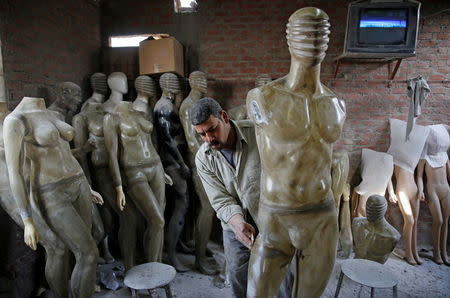 A worker fixes a fiberglass mannequin at a workshop in El Kharqanya village, El-Kalubia governorate, north of Cairo, Egypt, March 23, 2017. REUTERS/Amr Abdallah Dalsh