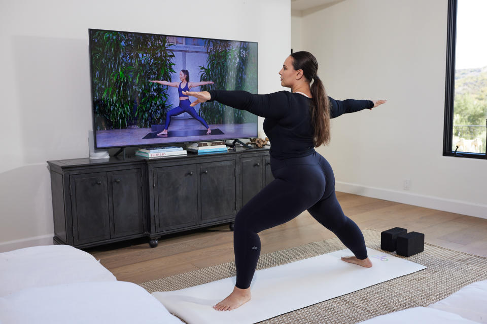 Woman working out to an Alo Moves virtual class. 