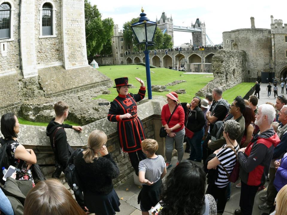 A "Beefeater" tourist guide showing tourists through the Tower of London.