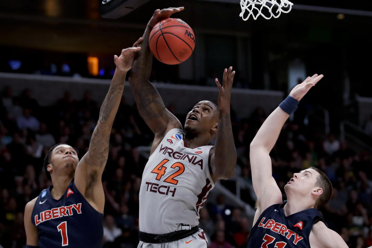 Virginia Tech guard Ty Outlaw, middle, vies for a rebound with Liberty guard Caleb Homesley, left, and Scottie James during the second half of a second-round game in the NCAA men's college basketball tournament Sunday, March 24, 2019, in San Jose, Calif. (AP Photo/Ben Margot)