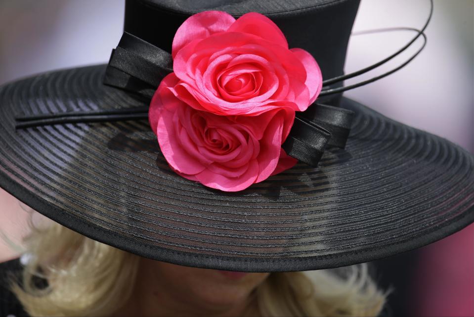A woman looks over a racing program before the 140th running of the Kentucky Derby horse race at Churchill Downs Saturday, May 3, 2014, in Louisville, Ky. (AP Photo/Darron Cummings)