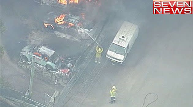 Firefighters hose down burnt out cars near Marsden Park. Photo: 7News