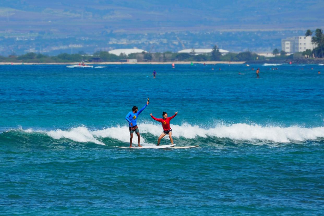 Asian tourist woman learning to surf in Waikiki, Honolulu