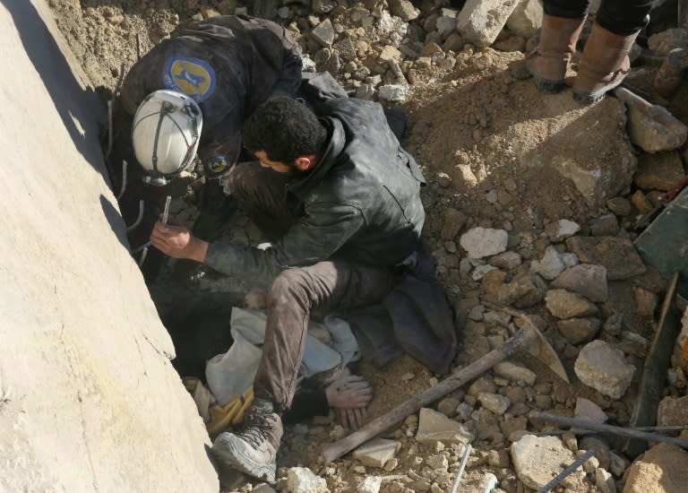Rescuers remove a victim from under the rubble following a reported air strike on the rebel-held neighbourhood of al-Kalasa in the northern Syrian city of Aleppo
