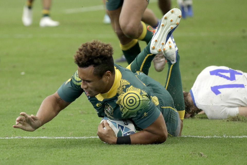 Australia's Will Genia scores a try during the Rugby World Cup Pool D game at Oita Stadium between Australia and Uruguay in Oita, Japan, Saturday, Oct. 5, 2019. (AP Photo/Aaron Favila)