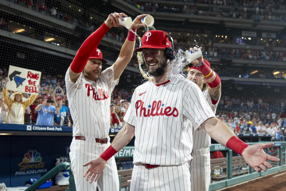 Philadelphia Phillies' David Dahl, center, is doused by Alec Bohm, left, and Bryson Stott, right, following a baseball game against the Milwaukee Brewers, Monday, June 3, 2024, in Philadelphia. (AP Photo/Chris Szagola)