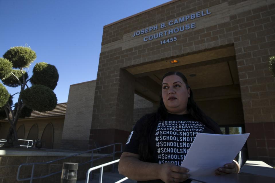 A woman stands in front of a courthouse