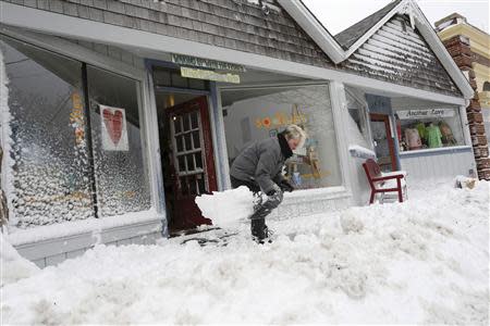 A shop-owner digs out a path in front of her store in Dennis, Massachusetts, March 26, 2014. REUTERS/Dominick Reuter