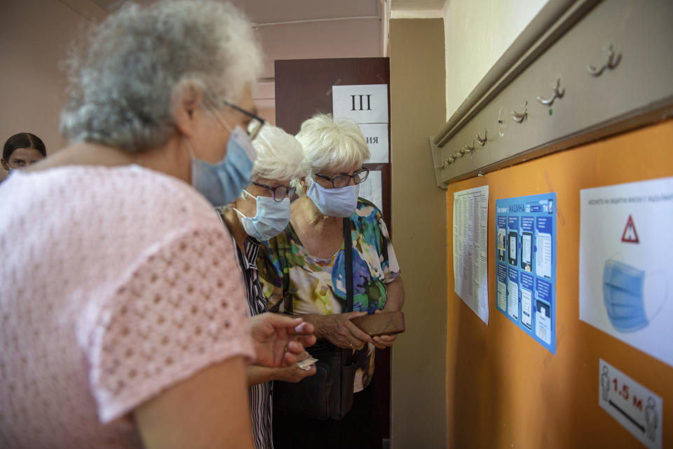 Bulgarian old women check the instructions on how to electronically vote during parliamentary elections in the town of Bankya near capital Sofia, Bulgaria on Sunday, July 11, 2021. Bulgarians are voting in a snap poll on Sunday after a previous election in April produced a fragmented parliament that failed to form a viable coalition government. Latest opinion polls suggest that the rerun could produce similar results but also a further drop in support for former Prime Minister Boyko Borissov's GERB party, after the current caretaker government made public allegations of widespread corruption during his rule. (AP PHOTO/Visar Kryeziu)