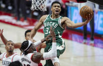 Milwaukee Bucks forward Giannis Antetokounmpo, right, shoots over Portland Trail Blazers forward Robert Covington during the second half of an NBA basketball game in Portland, Ore., Friday, April 2, 2021. (AP Photo/Craig Mitchelldyer)