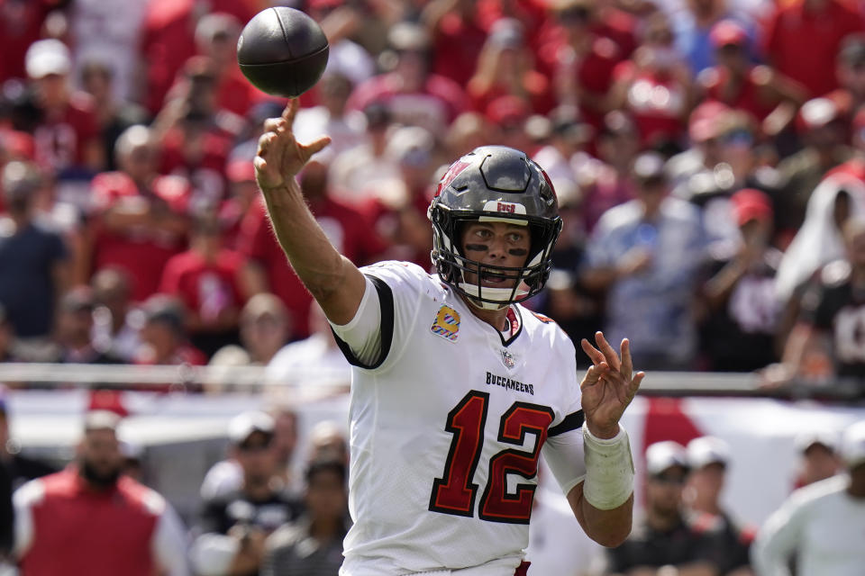 Tampa Bay Buccaneers quarterback Tom Brady (12) throws a touchdown pass to running back Leonard Fournette during the second half of an NFL football game against the Atlanta Falcons Sunday, Oct. 9, 2022, in Tampa, Fla. (AP Photo/Chris O'Meara)