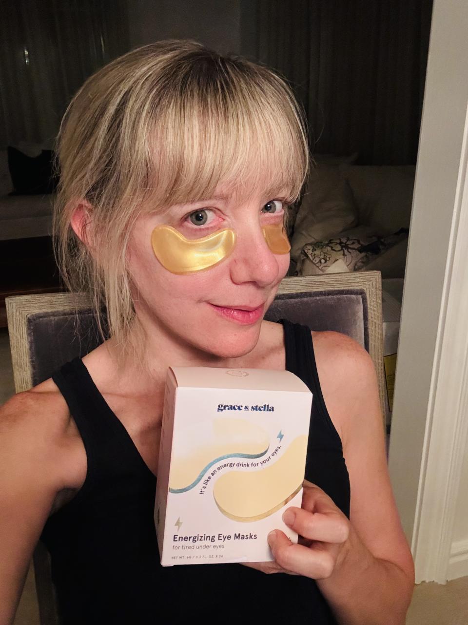 blonde woman holding box and wearing gold grace and stella under-eye masks