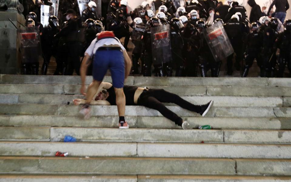 An injured demonstrator receives aid as he lies on the stairs of the Serbian parliament building,during a protest against a lockdown planned for Belgrade this weekend to halt a sruge in coronavirus.  - MARKO DJURICA/REUTERS