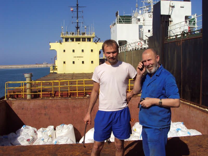 Boris Prokoshev, captain of cargo vessel Rhosus, and boatswain Boris Musinchak pose next to a freight hold in Beirut