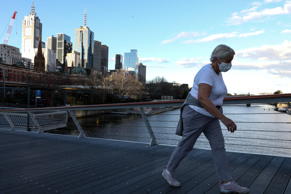 A woman wears a face mask as she crosses the Yarra River through an empty bridge in Melbourne. Source: Getty