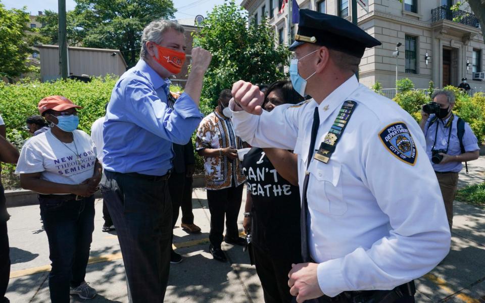 New York Mayor Bill de Blasio greets Inspector Isa Abbassi of the 120th Precinct as New York City's second Black Lives Matter mural is painted by volunteers between Borough Hall and the 120th Precinct in the Borough of Staten Island - AFP