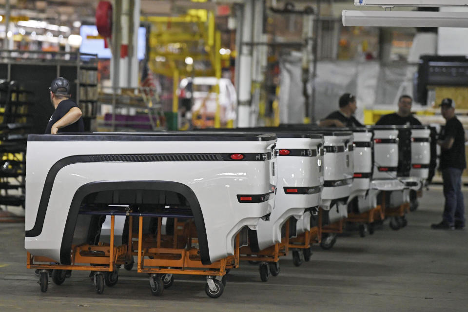 FILE - In this June 22, 2021, file photo, employees stand near Endurance truck beds during a media tour of the Lordstown Motors complex in Lordstown, Ohio. Lordstown Motors, an Ohio company that has come under scrutiny over the number of orders it claimed it had for the electric trucks that it wants to produce, acknowledged that it has received two subpoenas from federal regulators and that prosecutors in New York have opened an investigation. The Securities and Exchange Commission asked in a pair of subpoenas for documents related to the company's merger with DiamondPeak, a special purpose acquisition company. (AP Photo/David Dermer, File)