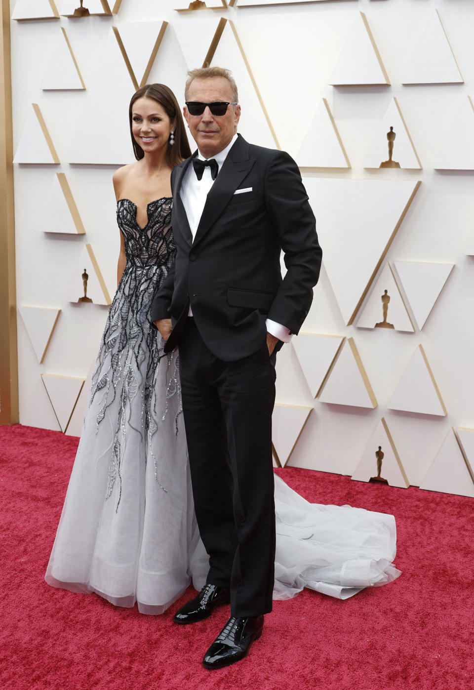 Kevin Costner and wife Christine Baumgartner pose on the red carpet during the Oscars arrivals at the 94th Academy Awards in Hollywood, Los Angeles, California, U.S., March 27, 2022. REUTERS/Eric Gaillard