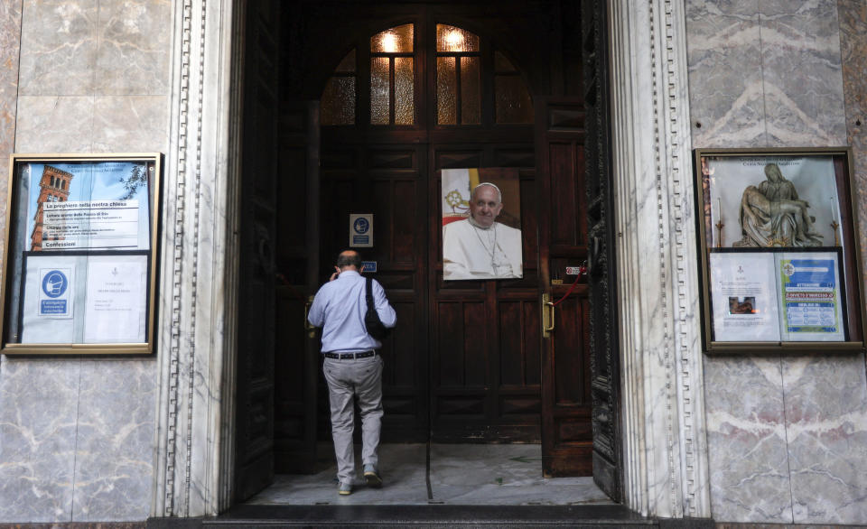 A man passes past a portrait of Pope Francis as he enters the Argentine church of Santa Maria Addolorata (Our Lady of Sorrows) in Rome, Sunday, July 4, 2021. Pope Francis was hospitalized in Rome on Sunday afternoon for scheduled surgery on his large intestine, the Vatican said. The news came just three hours after Francis had cheerfully greeted the public in St. Peter’s Square and told them he will go to Hungary and Slovakia in September. (AP Photo/Riccardo De Luca)