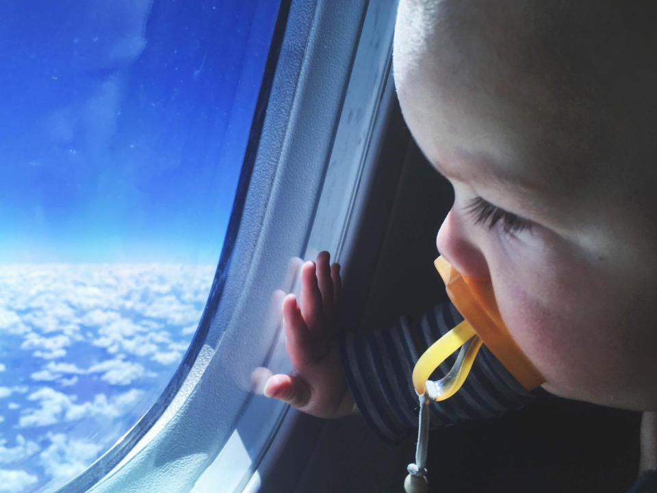 Toddler looking out an airplane window