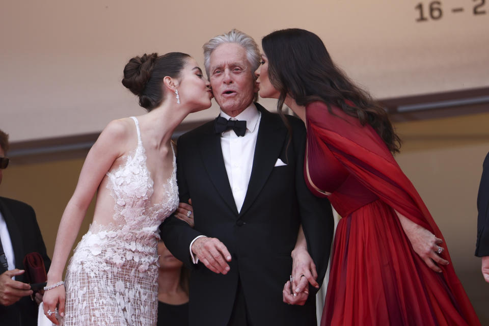 Carys Zeta Douglas, de izquierda a derecha, Michael Douglas y Catherine Zeta-Jones posan a su llegada a la ceremonia de apertura y al estreno de la película "Jeanne du Barry" en la 76a edición del festival internacional de cine de Cannes, en el sur de Francia, el martes 16 de mayo de 2023. (Foto Vianney Le Caer/Invision/AP)